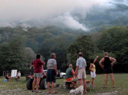 Bosniacoas observan el fuego forestal en el lago Boracko. AP  /