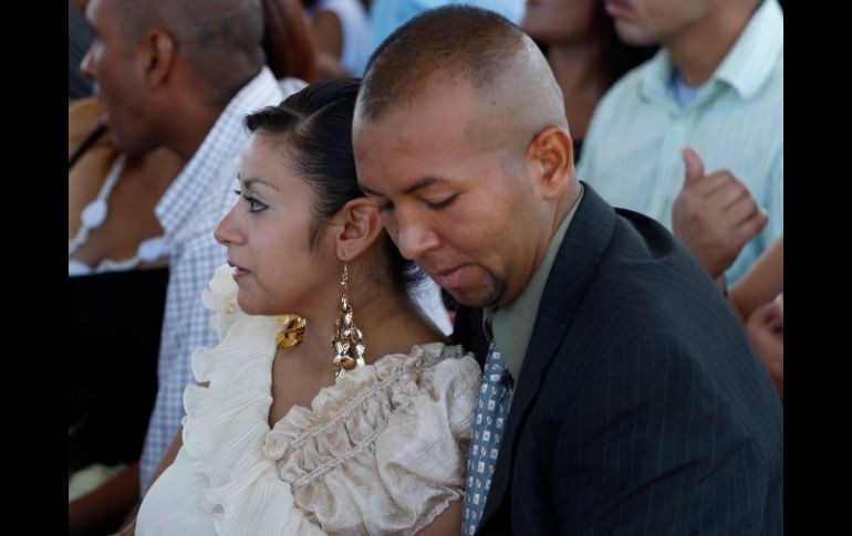 Un preso sostiene a su hijo mientras se encuentra con su novia en la ceremonia realizada en el Cereso 3. REUTERS  /