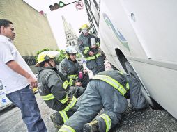 Bomberos revisan el camión que cayó en el hoyanco. Las primeras hipótesis apuntan a que hay agua fugándose de las redes subterráneas.  /