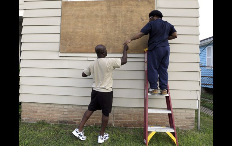 Vecinos aseguran las ventanas de sus casas en Nueva Orleans, previniendo la llegada de Isaac. AP  /