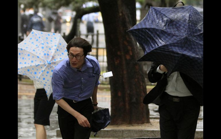 Ciudadanos de Seúl luchan contra los vientos huracanos del tifón para llegar a sus destinos. AP  /