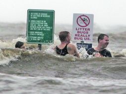 Contra el consejo de las autoridades tres jóvenes y un menor se divierten en las aguas del lago Pontchartrain, en Louisiana. AP  /