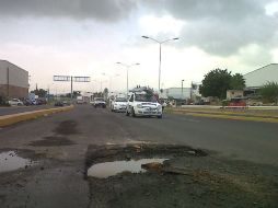 Los automovilistas tienen que esquivar el gran hoyo en el asfalto.  /