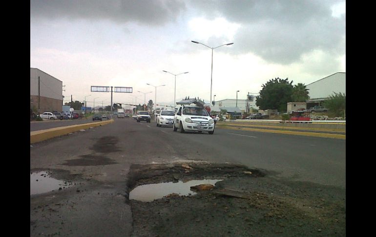 Los automovilistas tienen que esquivar el gran hoyo en el asfalto.  /