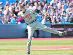 Con fuerza. Manny Machado se prepara para tirar a primera base, intentando poner fuera al corredor de los Azulejos. AFP  /