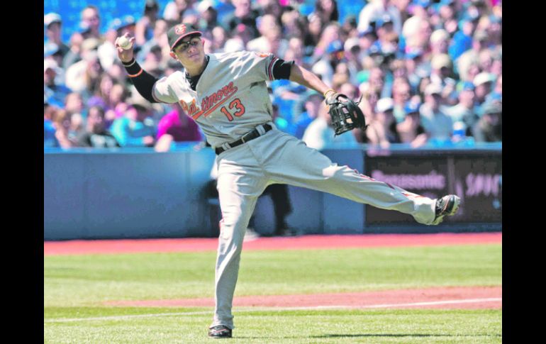 Con fuerza. Manny Machado se prepara para tirar a primera base, intentando poner fuera al corredor de los Azulejos. AFP  /