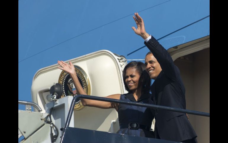 Barack Obama y su esposa, Michelle, se despiden antes de partir del aeropuerto internacional de Charlotte en Charlotte. AFP  /