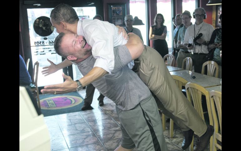 Gana la emoción. El dueño de una  pizzería levanta al presidente Barack Obama. AFP  /