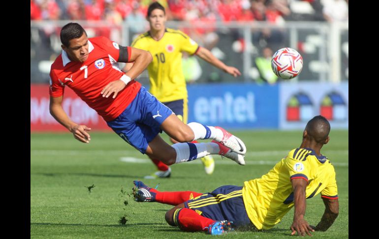 Alexis Sánchez recibe una dura barrida de parte de Luis Perez de Colombia. EFE  /