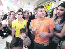 Apapachados. Iván García (amarillo) y Germán Sánchez firman autógrafos a la gente.  /