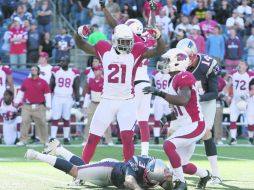 Stephen Gostkowski yace en el terreno, tras fallar su patada, mientras los jugadores de Arizona celebran la victoria en patio ajeno. AP  /