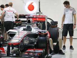 Jenson Button (der) observa la preparación de su auto por parte de los mecánicos de McLarren. AP  /