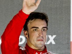 El piloto español de Fórmula Uno Fernando Alonso, saluda desde el podio. EFE  /