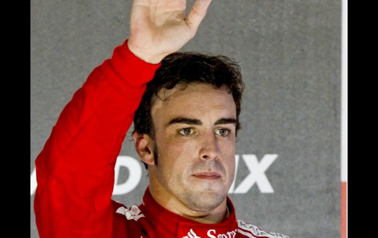 El piloto español de Fórmula Uno Fernando Alonso, saluda desde el podio. EFE  /