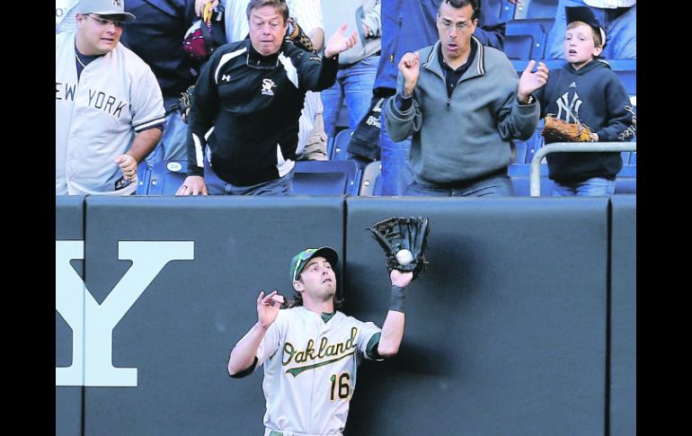 Susto. El jardinero Josh Reddick atrapa un elevado en el límite, en el noveno capítulo. AFP  /