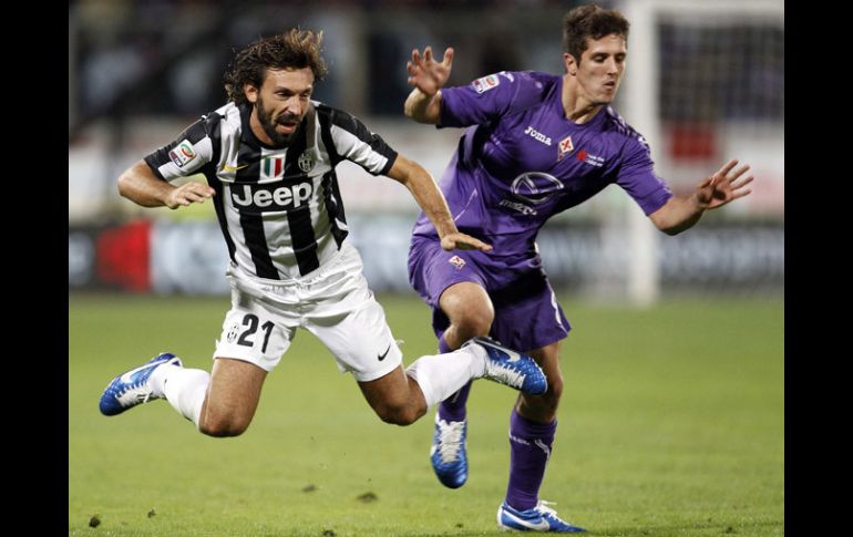 Andrea Pirlo (izq), cae luego de una falta durante el partido. REUTERS  /