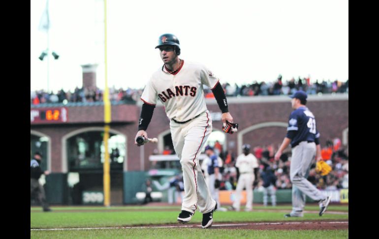 Productivo. Marco Scutaro trota al dugout de su equipo, tras anotar una carrera. AFP  /