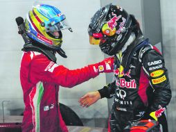 Suerte. Fernando Alonso (izq.) felicita a Sebastian Vettel, tras la carrera disputada en Singapur. AP  /