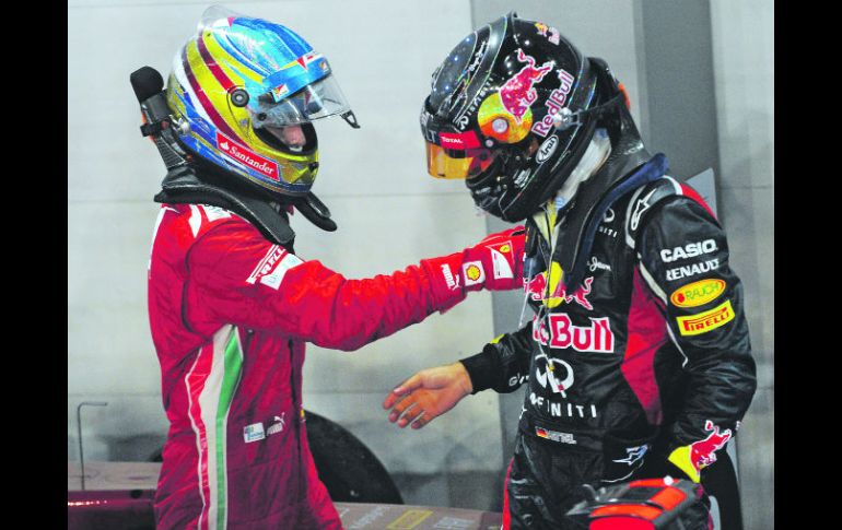 Suerte. Fernando Alonso (izq.) felicita a Sebastian Vettel, tras la carrera disputada en Singapur. AP  /