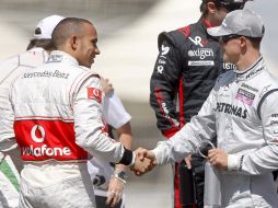 Hamilton y Schumacher se dan la mano como entregando al estafeta en el equipo Mercedes. EFE  /