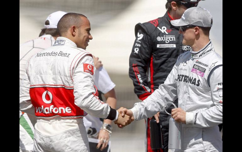 Hamilton y Schumacher se dan la mano como entregando al estafeta en el equipo Mercedes. EFE  /