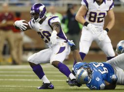 Adrian Peterson corre ante la fuerte defensiva de Detroit. AP  /