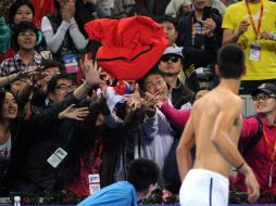 El serbio, Novak Djokovic, arroja su playera a sus fans luego del partido de semifinal en el Abierto de China. AFP  /