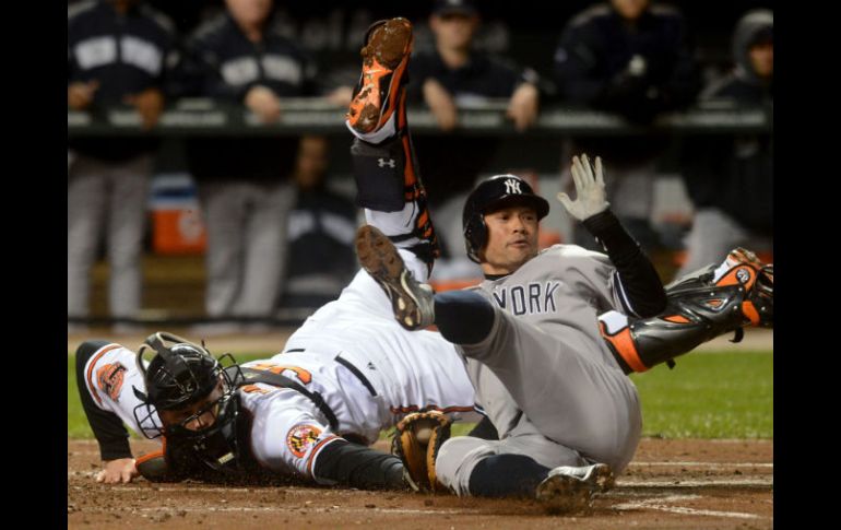 El jardinero izquierdo de Yanquis, Ichiro Suzuki evita ser ponchado por el receptor de Orioles, Matt Wieters. EFE  /