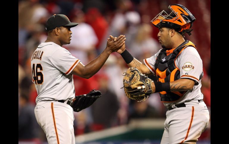 Héctor Sanchez (29) y el pitcher Santiago Casilla celebran la victoria ante Cincinnati. AFP  /