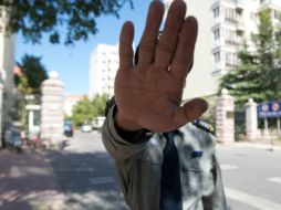 Un guardia chino obstruye la foto al conjunto habitacional donde la esposa de Liu Xiaobo se encuentra en arresto domiciliario. AFP  /