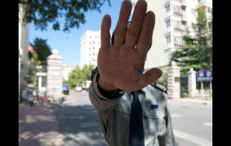 Un guardia chino obstruye la foto al conjunto habitacional donde la esposa de Liu Xiaobo se encuentra en arresto domiciliario. AFP  /