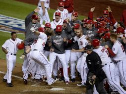 Jason Werth llega brincando al home para anotar la carrera con la que los Nacionales ganaron el partido. EFE  /