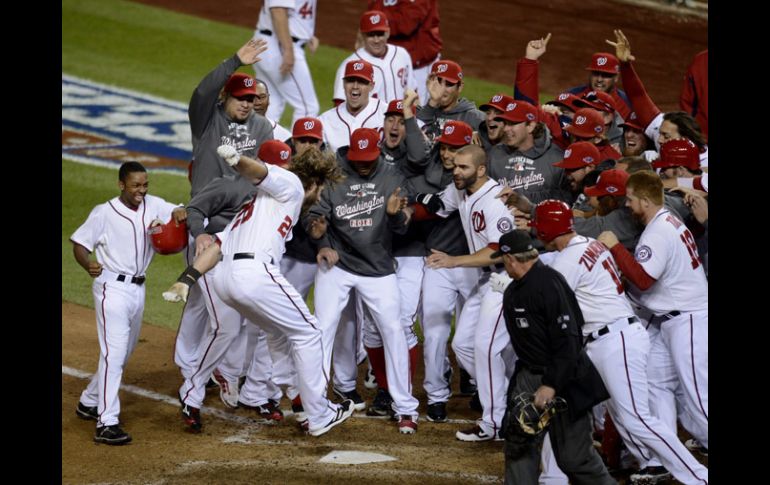 Jason Werth llega brincando al home para anotar la carrera con la que los Nacionales ganaron el partido. EFE  /