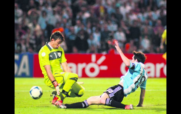 Lionel Messi se barre ante la salida del arquero uruguayo Fernando Muslera, para conseguir uno de sus dos goles. EFE  /