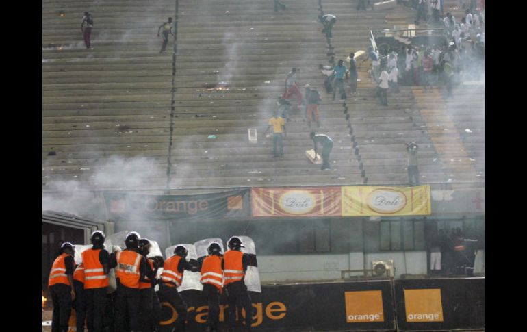 Polícias antidisturbios escoltan a la selección de Costa de Marfil luego de suspenderse el juego por violencia de afición. EFE  /