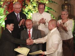 El presidente del FMLI, Murad Ebrahim(i), y el presidente filipino, Benigno Aquino III (2da d), firman el acuerdo. EFE  /