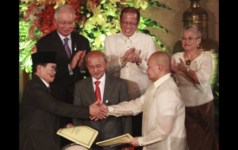 El presidente del FMLI, Murad Ebrahim(i), y el presidente filipino, Benigno Aquino III (2da d), firman el acuerdo. EFE  /