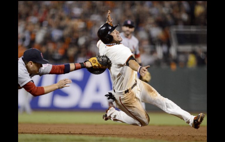 El jardinero derecho de San Francisco, Gregor Blanco (d), trata de evitar ser tocado por el primera base Allen Craig. EPA  /