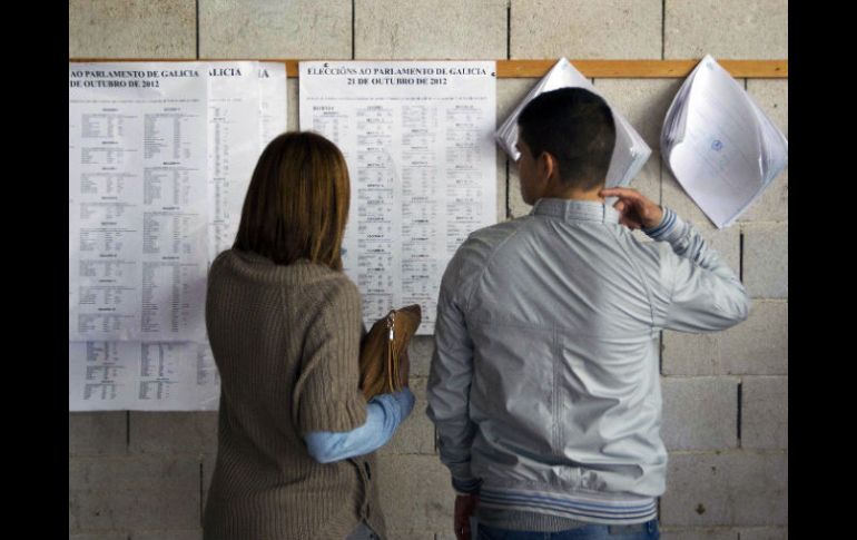 Dos votantes gallegos buscan información en las casillas electorales. AP .  /