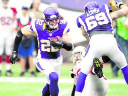 Harrison Smith (22) intenta avanzar tras interceptar un pase, mientras que Jared Allen (69) realiza un bloqueo. AP  /