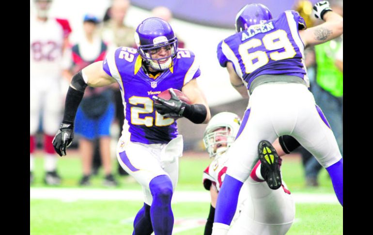 Harrison Smith (22) intenta avanzar tras interceptar un pase, mientras que Jared Allen (69) realiza un bloqueo. AP  /