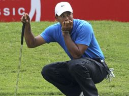 El golfista estadounidense, Tiger Woods analiza su siguiente golpe durante la primera jornada del torneo de golf. EFE  /