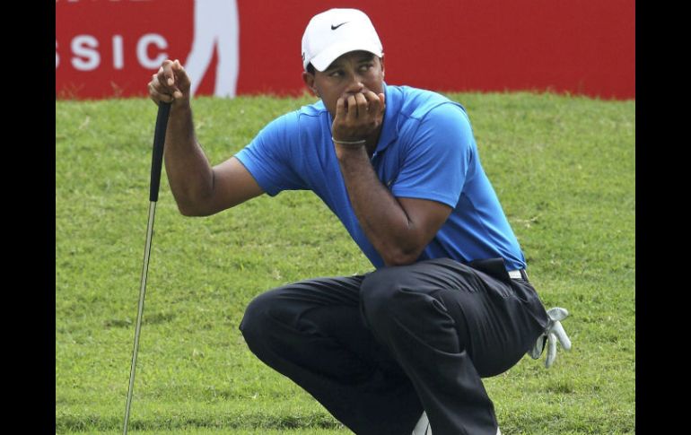 El golfista estadounidense, Tiger Woods analiza su siguiente golpe durante la primera jornada del torneo de golf. EFE  /