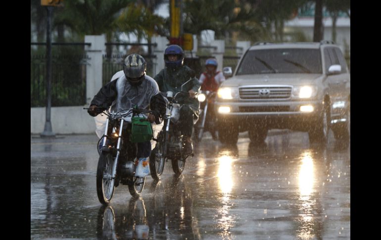 Conductores circulan bajo la lluvia  causada por ''Sandy''. EFE  /