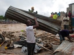 Hombres en Puerto Príncipe, Haití, recogen partes de una casa que fueron derribadas por el huracán. AP  /