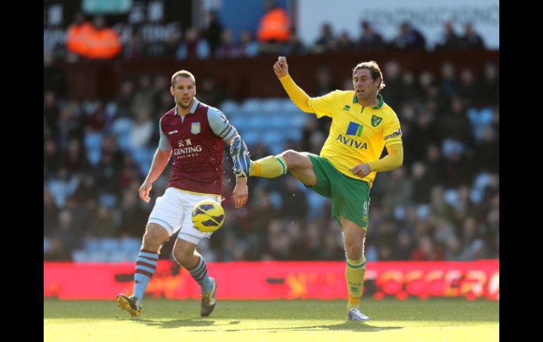 Ron Vlaar del Aston Villa (i) y Grant Holt (d) del Norwich City en batalla por el balón. AP  /