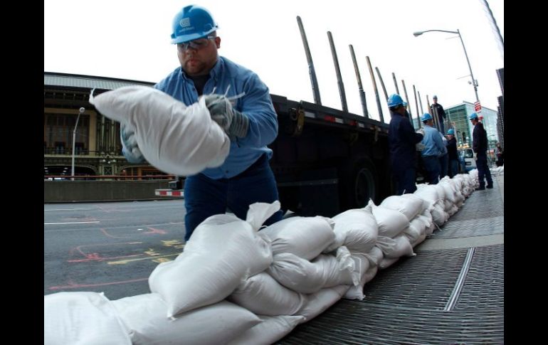 Trabajadores en Nueva York colocan sacos de arena para cubrir bóvedas de energía previo a la llegada de 'Sandy'. REUTERS  /