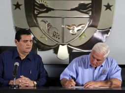 El presidente panameño, Ricardo Martinelli (d), acompañado por el presidente de la Asamblea Nacional firma la derogación. EFE  /