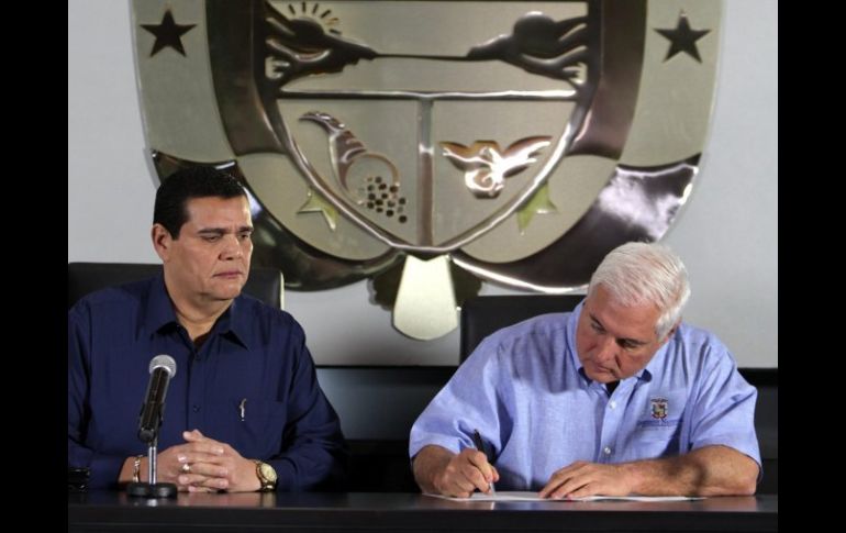 El presidente panameño, Ricardo Martinelli (d), acompañado por el presidente de la Asamblea Nacional firma la derogación. EFE  /