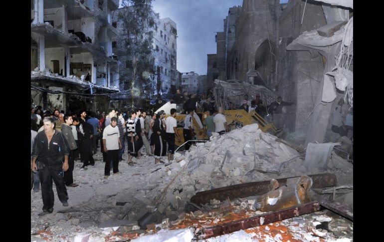 Ciudadanos sirios en el lugar donde se registró la explosión de un coche bomba en el barrio de Def al Shuk en Damasco. EFE  /